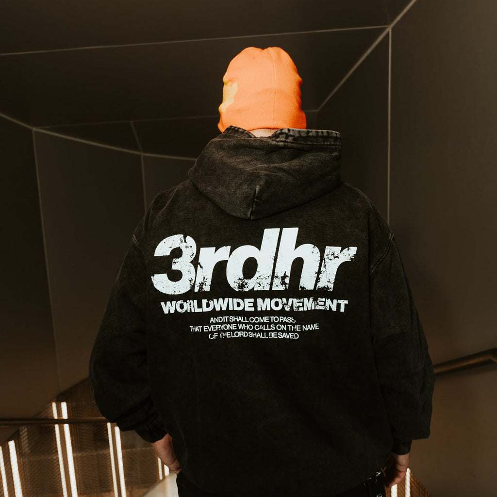 Person wearing a black hoodie with '3rdhr Worldwide Movement' text in an indoor setting.